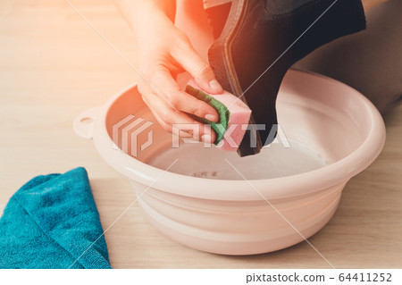 Cleaning and washing dirty shoes concept. Person's 64411252