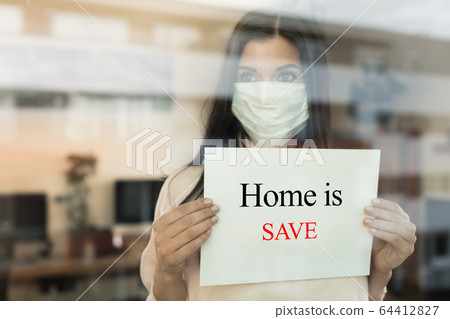 Young woman with paper sign looking through window Young woman with paper sign looking through window 64412827