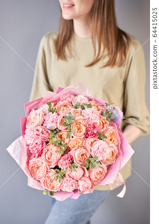 Beautiful bouquet of mixed flowers in womans hands. the work of the florist at a flower shop. Delivery fresh cut flower. European floral shop. Beautiful bouquet of mixed flowers in womans hands. the work of the florist at a flower shop. Delivery fresh cut flower. European floral shop. 64415025