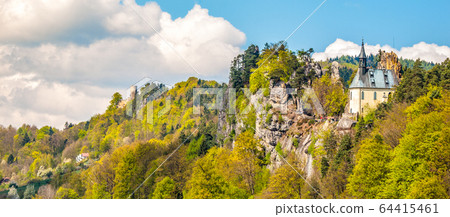 Ruins of Vranov Castle with small rock chapel, aka Pantheon, in Mala Skala on sunny summer day with blue sky and lush green trees, Bohemian Paradise, aka Cesky Raj, Czech Republic Ruins of Vranov Castle with small rock chapel, aka Pantheon, in Mala Skala on sunny summer day with blue sky and lush green trees, Bohemian Paradise, aka Cesky Raj, Czech Republic 64415461