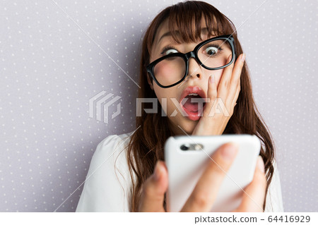 智能手機/驚訝的女人。 智能手機/驚訝的女人。 64416929