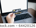 Women's hand holding credit card and using laptop for shopping online 64420126