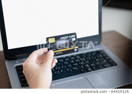 Women's hand holding credit card and using laptop for shopping online 64420126