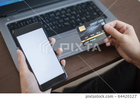 Close up hand of women holding credit card and smartphone for payment shopping online in smart life concept 64420127