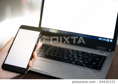 Close up hand of women using smartphone and laptop in working concept 64420131