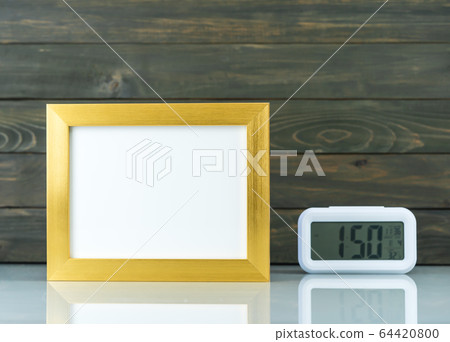 Blank golden frame and digital alarm clock on Blank golden frame and digital alarm clock on 64420800