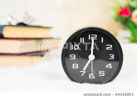 Black alarm clock on table Black alarm clock on table 64420801