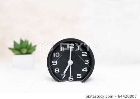 Black alarm clock and little decorative tree in 64420803