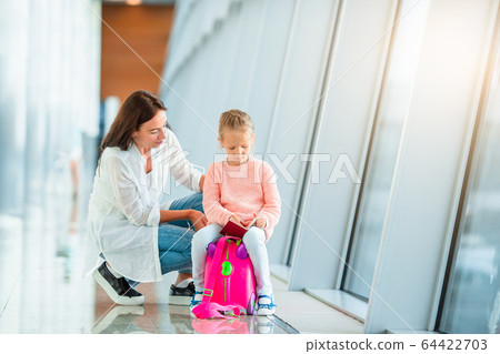 Happy mum and little girl with boarding pass at airport Happy mum and little girl with boarding pass at airport 64422703