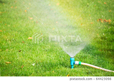 Water sprinkler spraying water on grass Water sprinkler spraying water on grass 64423098