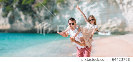 Happy father and his adorable little daughter at tropical beach having fun Happy father and his adorable little daughter at tropical beach having fun 64423768