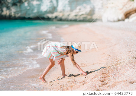 Adorable active little girl at beach during summer vacation Adorable active little girl at beach during summer vacation 64423773