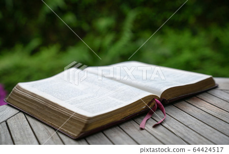 Open bible on wooden table. Soft focus, blur text. Open bible on wooden table. Soft focus, blur text. 64424517