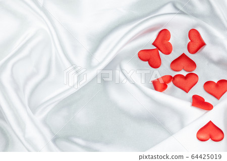 Many red hearts on a wrinkled white background Many red hearts on a wrinkled white background 64425019