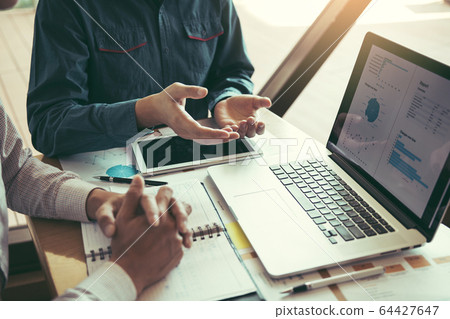 Manager is sitting to explain about the cost of Manager is sitting to explain about the cost of 64427647