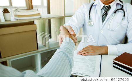 Doctor shaking hands with older patient in the 64427693