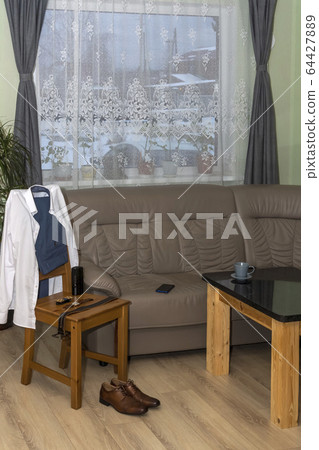 Men's wear, shoes and accessories on chair by the sofa in the morning 64427889