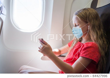 Adorable little girl traveling by an airplane. Adorable little girl traveling by an airplane. 64427996