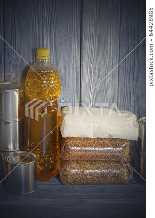 canned food and various cereals on a wooden shelf, food crisis 64428985