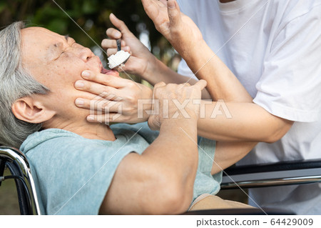 Force-feeding because asian senior woman refuses,does not want to eat food,angry female caregiver scolding,force feeding a meal for elderly people,stop physical abuse,violence,aggression,coercion Force-feeding because asian senior woman refuses,does not want to eat food,angry female caregiver scolding,force feeding a meal for elderly people,stop physical abuse,violence,aggression,coercion 64429009