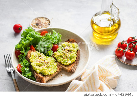 Vegan bread toast with avocado smash and seeds 64429443