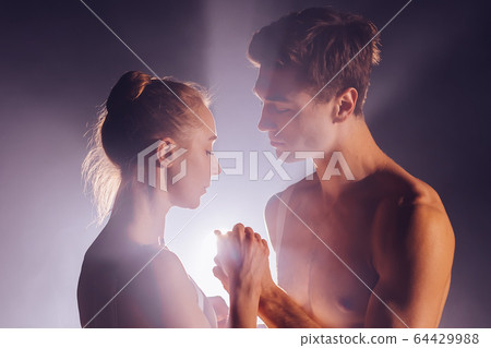 Romantic professional ballet pair practicing moves on dark stage. Young couple dancing in classic Romantic professional ballet pair practicing moves on dark stage. Young couple dancing in classic 64429988