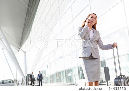 Young attractive businesswoman talking on 64433550
