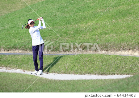Image of a woman hitting the approach from the rough 64434408
