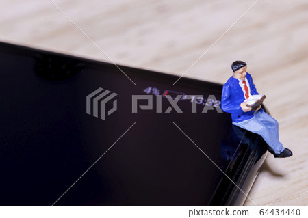 A man reading with a smartphone with a low battery 64434440