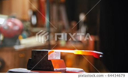 Forging an object out of hot metal using a pressure machine 64434679
