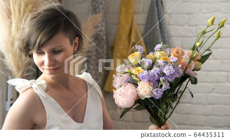 Woman gardener in flower shop make bouquet. Woman gardener in flower shop make bouquet. 64435311