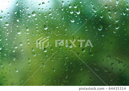 Raindrops on window pane with blurred background. Raindrops on window pane with blurred background. 64435314