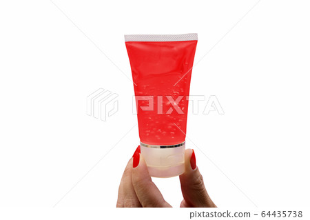 The woman's hand holding a red gel tube on a white The woman's hand holding a red gel tube on a white 64435738