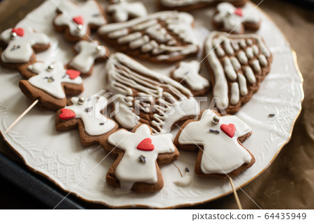 Homemade cookies in shape of angels and wings. 64435949