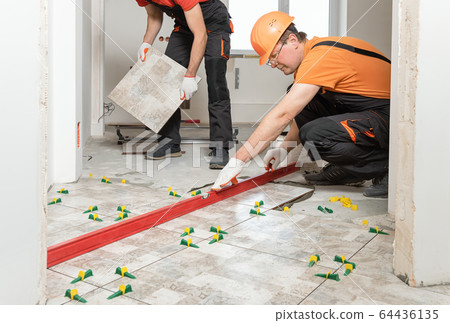 Installing ceramic tiles on the floor. Installing ceramic tiles on the floor. 64436135