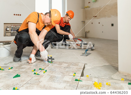 Installing ceramic tiles on the floor. Installing ceramic tiles on the floor. 64436203