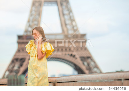 Beautiful woman in Paris background the Eiffel tower during her vacation Beautiful woman in Paris background the Eiffel tower during her vacation 64436956