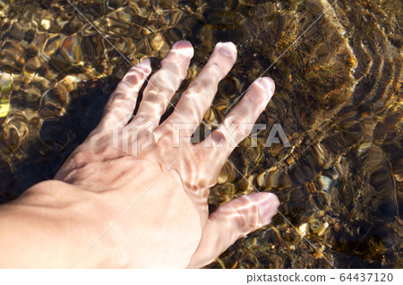 Dipping your hands in river water Dipping your hands in river water 64437120