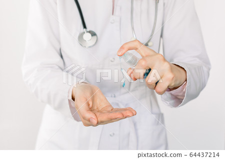 Cropped image of female doctor hands using wash hand sanitizer gel dispenser, against coronavirus or Covid-19. Antiseptic, Hygiene and Healthcare concept. Isolated on white background 64437214