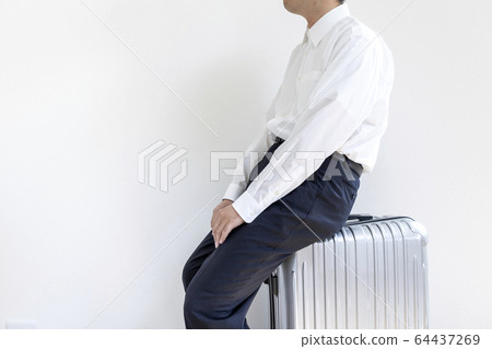 Man in shirt resting sitting on suitcase 64437269
