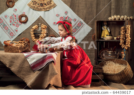 Adorable girl pouring tea from samovar 64439017
