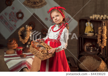 Pretty girl holding basket of bagels and other baking in traditional house Pretty girl holding basket of bagels and other baking in traditional house 64439020