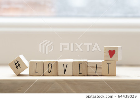 Wooden cubes with a hashtag and the words love it, social media concept background Wooden cubes with a hashtag and the words love it, social media concept background 64439029