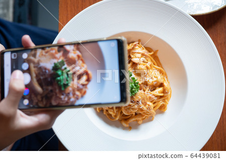 hand taking photo of food with smartphone to share on social media (shooting before eating) hand taking photo of food with smartphone to share on social media (shooting before eating) 64439081