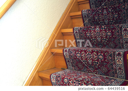 Stairs with red pattern carpet strip, old vintage wooden staircase, antique design 64439516
