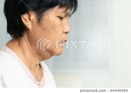 Close-up of Asian elder woman face with wrinkled skin condition. side view 64440464