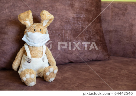 Easter bunny at home in face mask symbolizing lonely Easter 2020. Easter bunny at home in face mask symbolizing lonely Easter 2020. 64442540