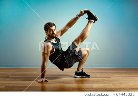 A man does functional exercises in the gym on a gray background. Fitness concept, sports body, body positive, copy space A man does functional exercises in the gym on a gray background. Fitness concept, sports body, body positive, copy space 64443323