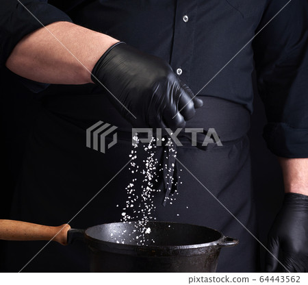male cook in black uniform and latex gloves salt 64443562