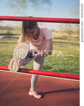 Woman Stretching in the Park 64444283